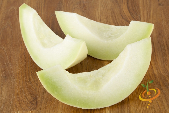 Three slices of green flesh honeydew melon on a wooden surface